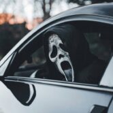 Maskis isik autos sümboliseerimas automüügipettust ja varjatud vigadega sõidukit