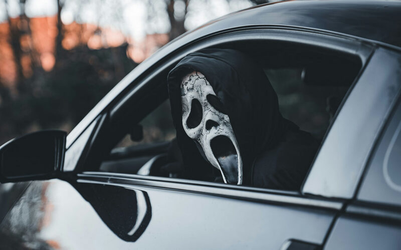 Maskis isik autos sümboliseerimas automüügipettust ja varjatud vigadega sõidukit