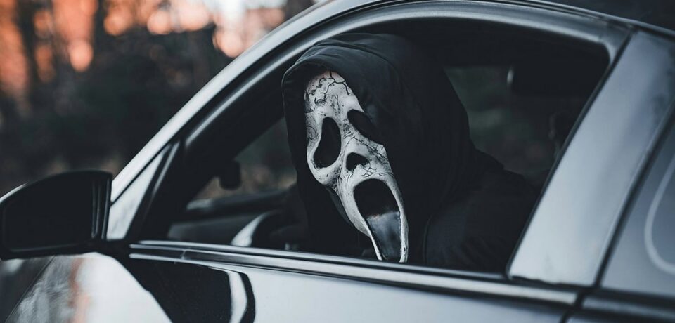 Maskis isik autos sümboliseerimas automüügipettust ja varjatud vigadega sõidukit