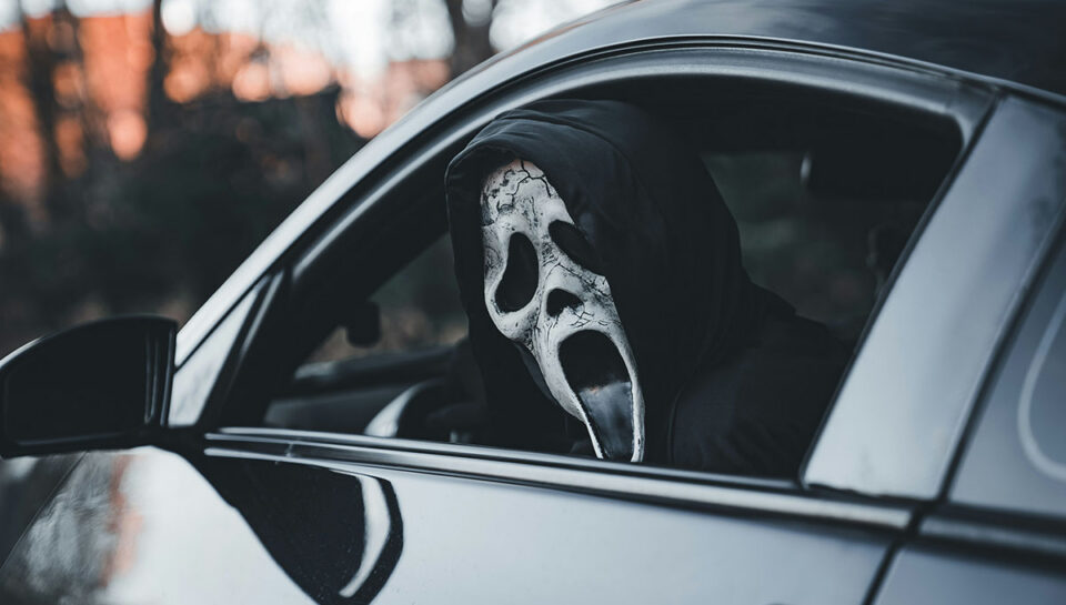 Maskis isik autos sümboliseerimas automüügipettust ja varjatud vigadega sõidukit